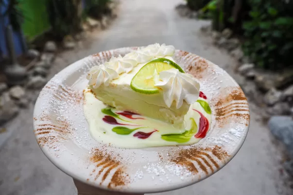 hand holding plate with slice of key lime pie.